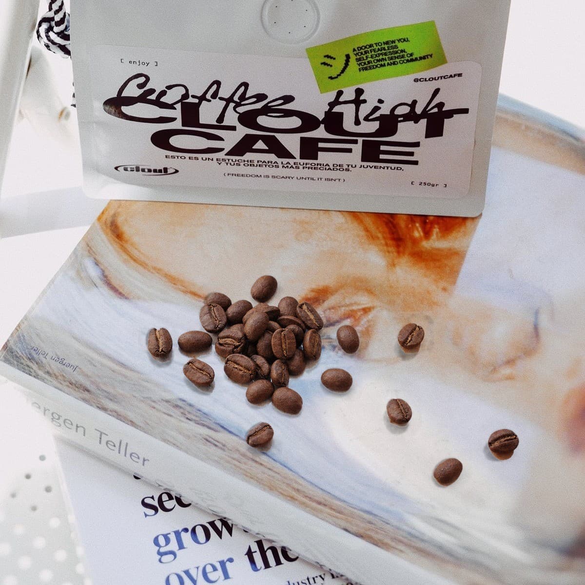 Bolsa de café Clout sobre un libro, con granos de café